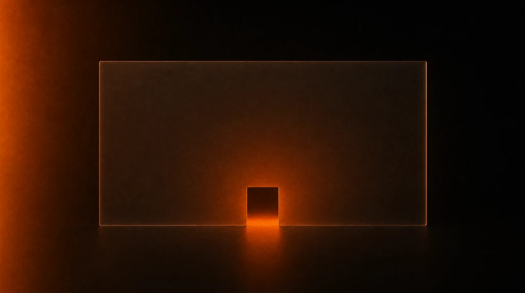 A tall frosted glass wall in darkness with a small doorway at its base lit from behind in warm orange