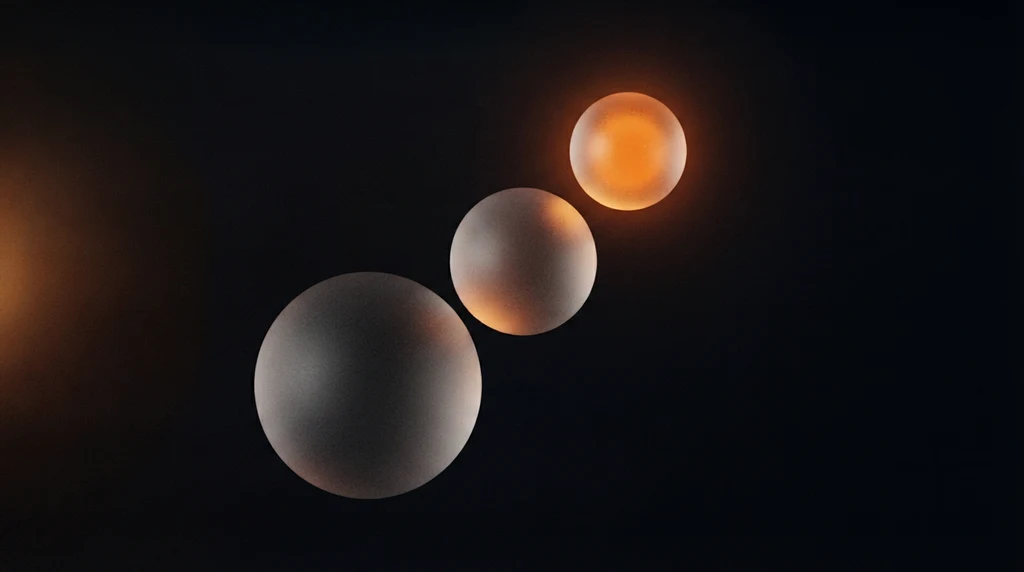 Three frosted glass spheres of different sizes in a diagonal line, the smallest glowing warm orange from within