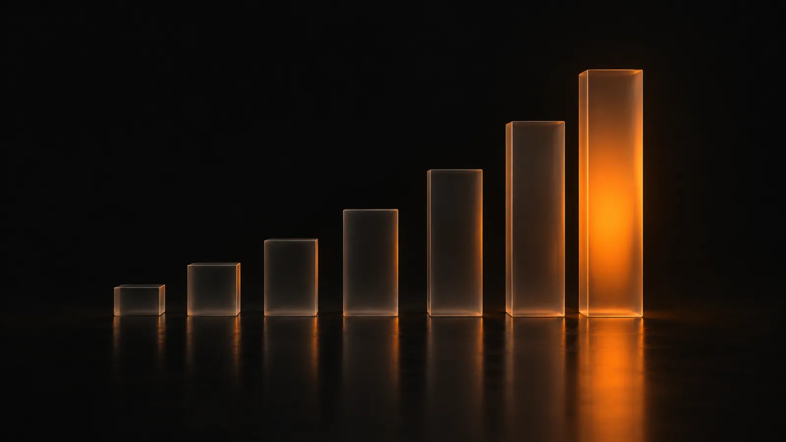Frosted glass columns rising from left to right in the dark, the tallest one lit from inside by a warm orange glow